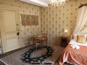 1 dormitorio con mesa, cama y puerta en Maison Porte del Marty, en Lalinde