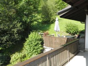una terraza con sombrilla y una mesa con una silla en Apartment Goldrose by Interhome en Zweisimmen