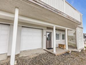 a white house with two garage doors and a bench at Holiday Home Ylläksen rinnemäki c by Interhome in Ylläs