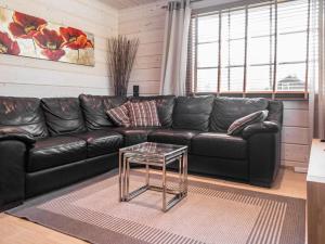 a black leather couch in a living room with a glass table at Holiday Home Villa illi by Interhome in Tahkovuori