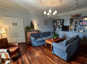 a living room with two blue couches and a table at La Maison de Fleurat in Domeyrot