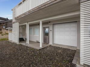 ein Haus mit einer Garagentür und einem Hund auf einer Veranda in der Unterkunft Holiday Home Ylläksen rinnemäki a by Interhome in Ylläs