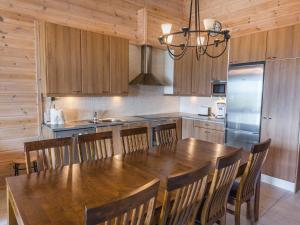 a kitchen with a wooden table and wooden cabinets at Holiday Home Ylläksen rinnemäki c by Interhome in Ylläs +11 photos