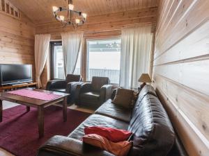 a living room with a leather couch and a table at Holiday Home Ylläksen rinnemäki c by Interhome in Ylläs
