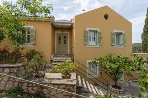 a yellow house with a green door and stairs at Yellow House Ithaca in Vathi, Ithaka