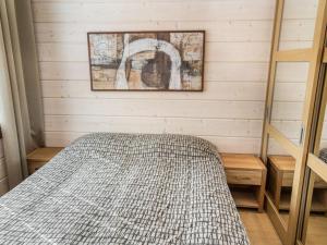 a bedroom with a bed and a picture on the wall at Holiday Home Villa illi by Interhome in Tahkovuori