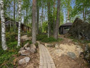 einen Weg, der zu einer Hütte im Wald führt in der Unterkunft Holiday Home Hiidenlinna by Interhome in Pitkälahti