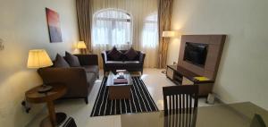 ein Wohnzimmer mit Sofas und einem TV im Zimmer in der Unterkunft Ivory Hotel Apartments in Abu Dhabi