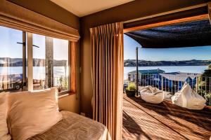 a bedroom with a bed and a large window at Journeys end in Raglan