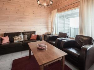 uma sala de estar com sofás de couro e uma mesa em Holiday Home Ylläksen rinnemäki a by Interhome em Ylläs
