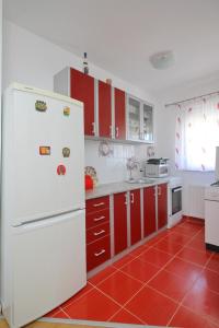 een keuken met rode kasten en een witte koelkast bij Vila Mija in Zlatibor