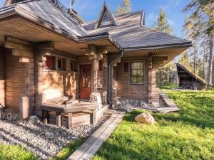 a small wooden house with a porch in the grass at Holiday Home Ylläskyrö by Interhome in Ylläsjärvi