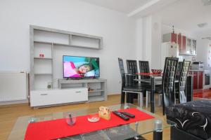 a living room with a tv and a table and chairs at Vila Mija in Zlatibor