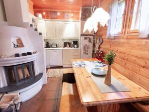 a kitchen with a wooden table and a fireplace at Holiday Home Alppitalo b by Interhome in Ylläsjärvi