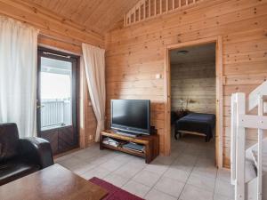 ein Wohnzimmer mit einem Flachbild-TV in einer Blockhütte in der Unterkunft Holiday Home Ylläksen rinnemäki a by Interhome in Ylläs
