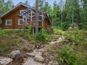 una cabaña de madera en el bosque con un camino que conduce a ella en Holiday Home Neitlinna by Interhome, en Pitkälahti
