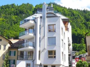 ein weißes Gebäude mit Balkonen auf einem Berg in der Unterkunft Apartment Villa Maria 33 by Interhome in Engelberg
