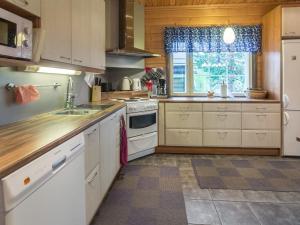 a kitchen with white cabinets and a sink and a window at Holiday Home Tuulenpuuska by Interhome in Äkäslompolo +11 photos