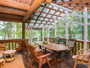 eine Holzterrasse mit einem Holztisch und Stühlen in der Unterkunft Holiday Home Hiidenlinna by Interhome in Pitkälahti + 30 Fotos