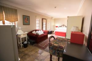 a living room with a bed and a couch at MacGregors Guest House in Pretoria
