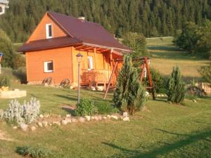 a log cabin with a porch and a playground at Chata Linda in Huty