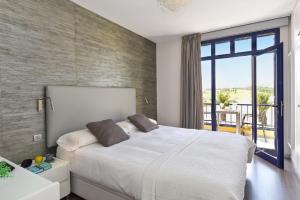 a bedroom with a large white bed and a balcony at Casas Meloneras by VillaGranCanaria in Meloneras