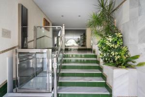 una escalera de color verde y blanco con plantas en Arcos Beach Infostays - Free Parking, en Málaga