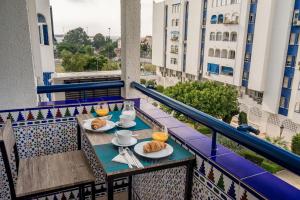 una mesa con 2 platos de comida en el balcón en Arcos Beach Infostays - Free Parking, en Málaga