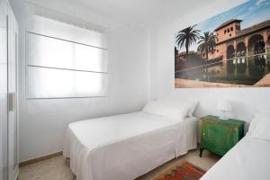1 dormitorio con 2 camas y un cuadro en la pared en Arcos Beach Infostays - Free Parking, en Málaga