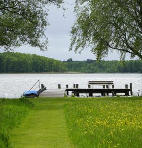a dock on a lake with a boat in the water at Ferien in Himmelpfort in Himmelpfort