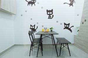 una sala da pranzo con tavolo e gatti neri sul muro di Ezzyhome@Medini a Nusajaya