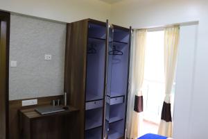 ein Schlafzimmer mit einem Schrank mit blauen Regalen und einem Fenster in der Unterkunft Emerald Vista Luxury Suites in Pune