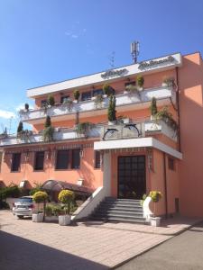 um edifício rosa com uma escada em frente em Albergo Ristorante Il Delfino em Novara