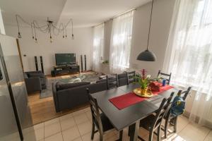 a dining room and living room with a table and chairs at Sopron City Apartment in Sopron