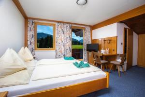 una camera d'albergo con un letto, una scrivania e una finestra di Berghof Mitterberg a Gröbming