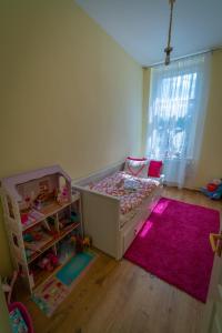 a childs bedroom with a bed and a pink rug at Sopron City Apartment in Sopron