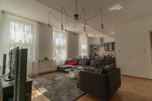 a living room with a couch and a tv at Sopron City Apartment in Sopron