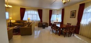 a living room with a table and chairs and a couch at Ivory Hotel Apartments in Abu Dhabi