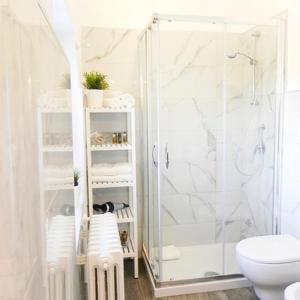 a white bathroom with a shower and a toilet at Resort Pietra Bianca in Noci