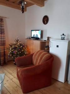 a living room with a couch and a christmas tree at Chata Linda in Huty
