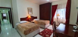pokój z 2 łóżkami w pokoju hotelowym w obiekcie Ivory Hotel Apartments w Abu Zabi