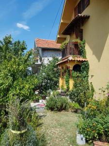 einen Garten vor einem Gebäude mit Balkon in der Unterkunft B&B Jonovic in Donji Milanovac