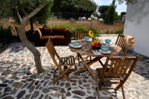 a wooden table and chairs on a patio at Goodmuda Tipi's in Grândola