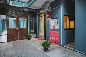 uma fachada de um edifício com portas e vasos de plantas em RedDoorz near RSUD Koja em Jakarta