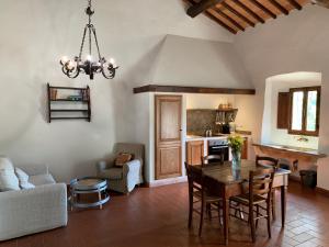 a living room with a table and a kitchen at Querceto Di Castellina in Castellina in Chianti