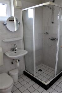 a bathroom with a shower and a toilet and a sink at 6-pers vakantiebungalow in het Heuvelland in Simpelveld