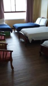 a room with three beds sitting on a wooden floor at PRIVATE suite AT CAMP JOHN HAY FOREST LODGE in Camp John Hay