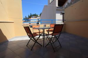 uma mesa e cadeiras numa varanda com vista em Penthouse Alma Vivoda em Piran