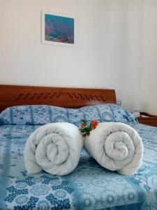 łóżko z dwoma rolkami ręczników w obiekcie MARGIE'S HOUSE w mieście Procida