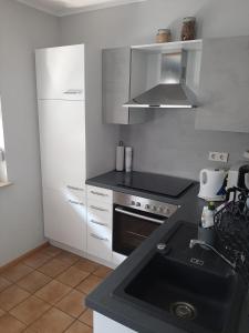 a kitchen with a black sink and a stove at Ferienwohnungen Wittmann in Bad Staffelstein